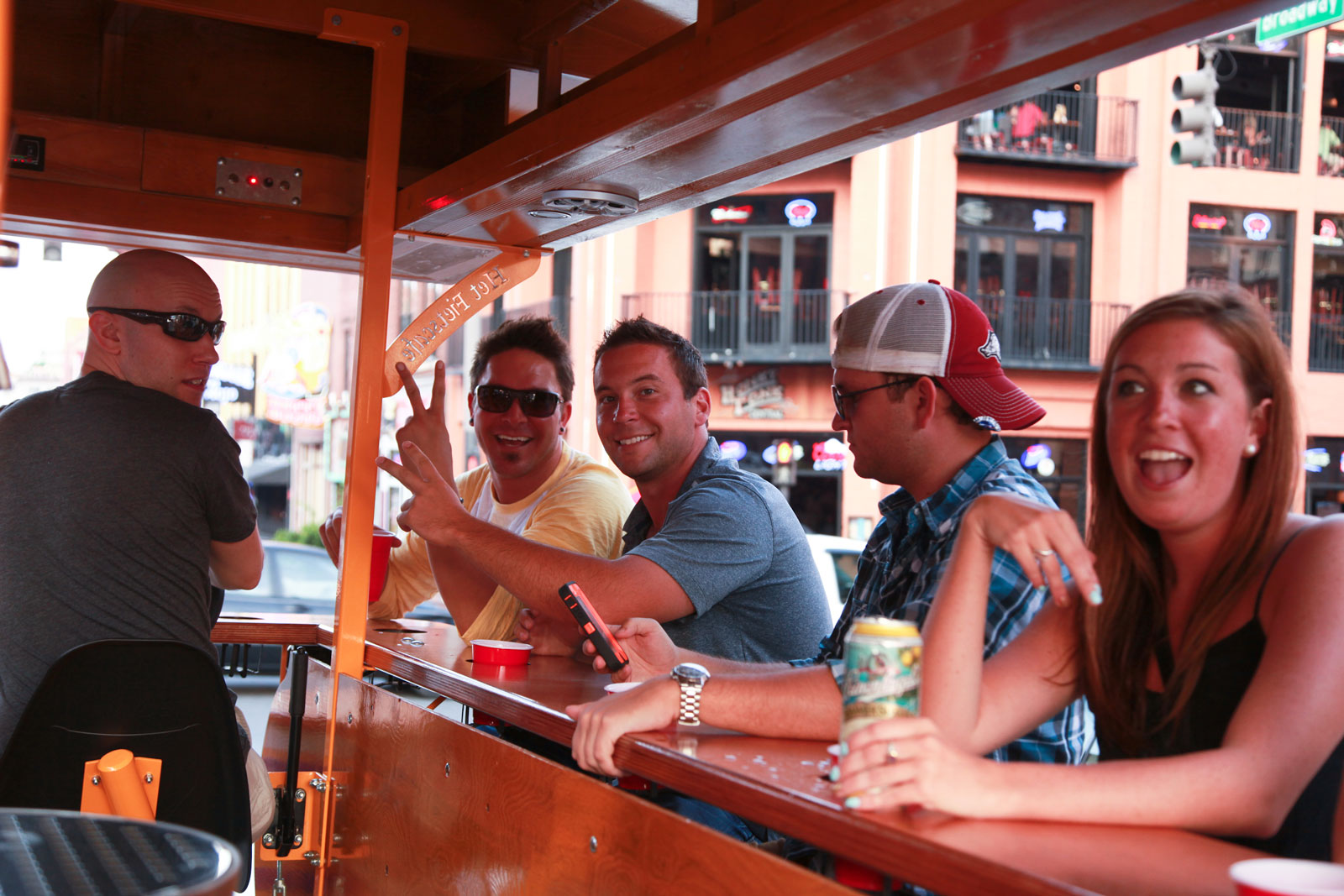 Two Pedal Tavern riders giving the peace sign - best things to do in nashville, nashville tourist attractions, fin things to do in nashville