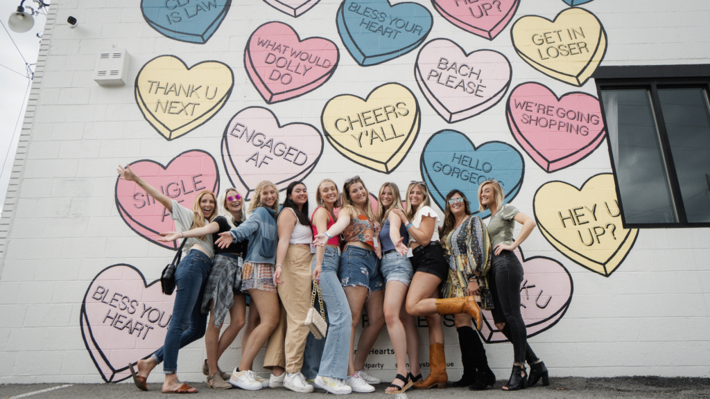 group of women posing in front of an iconic nashville mural on a photowalk tour