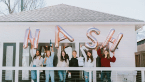 Bachelorette party holding up balloons that spell "NASH" at a Nashville airbnb